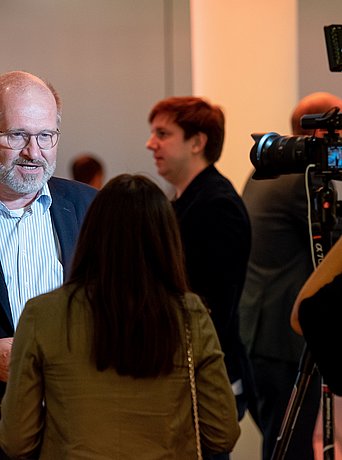 A person from the Greentech.Ruhr network is interviewed at an event.
