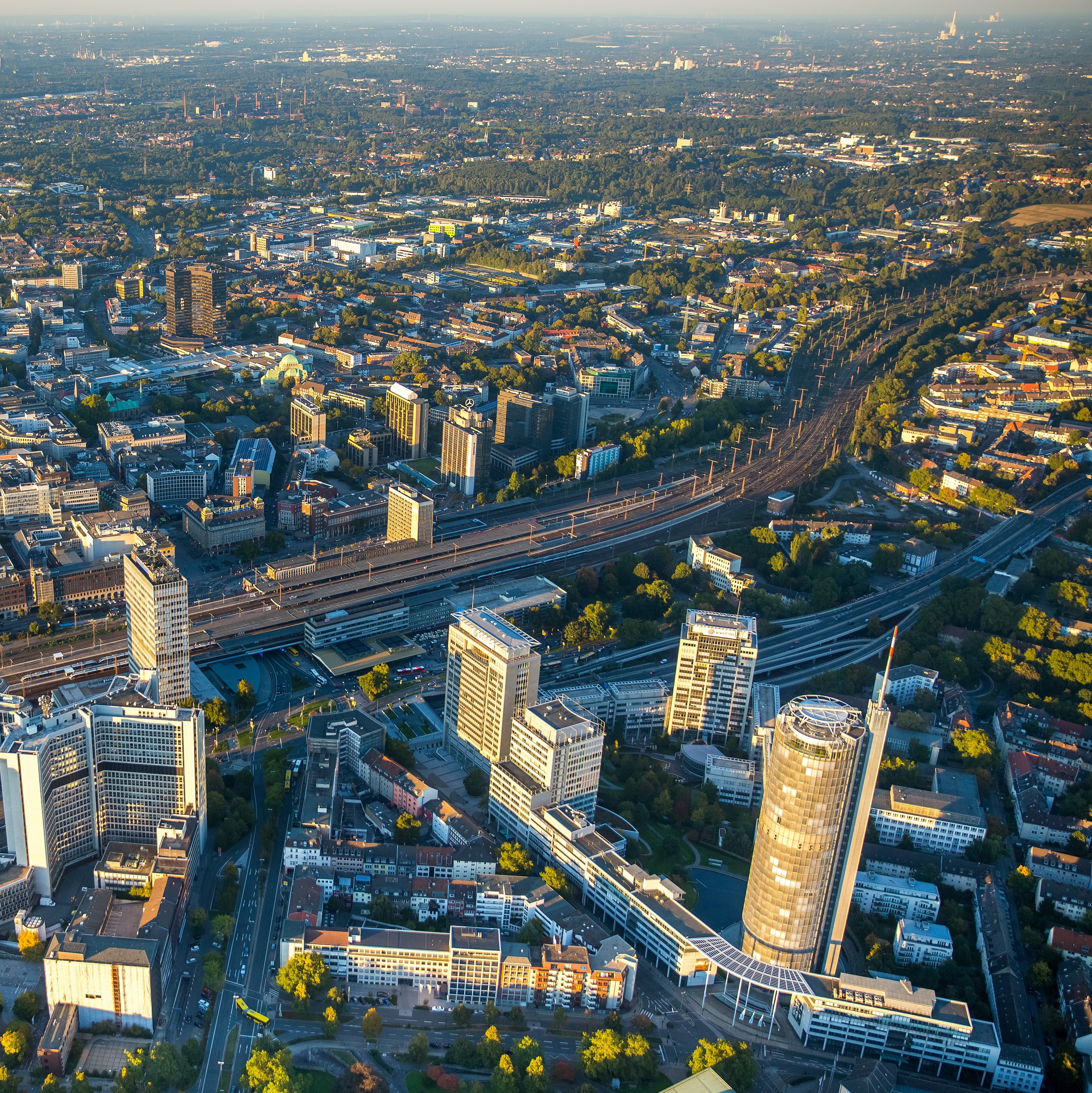 Abgebildet ist das Ruhrgebiet von oben. Zu sehen sind viele moderne Bürogebäude und die Autobahn innerhalb der Stadt.