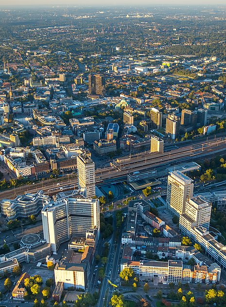 Pictured is the Ruhr area from above. You can see many modern office buildings and the highway inside the city.