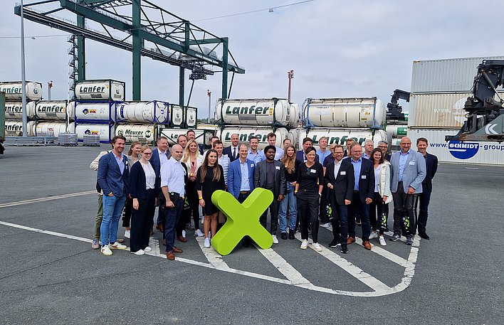 Gruppenfoto einer Gruppe der Investorentour Ruhr, die versammelt um ein grünes X herum steht.